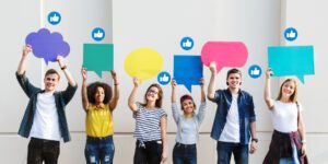 Imagen de adolescentes sosteniendo carteles de comunicación delante de un muro